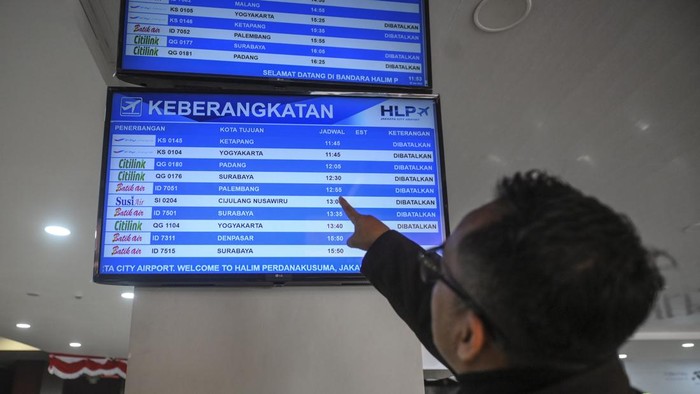 Calon penumpang melihat layar informasi penerbangan di Bandara Halim Perdanakusuma, Jakarta, Minggu (6/9/2026). Bandara Halim Perdanakusuma menutup sementara aktivitas penerbangan akibat adanya sebaran abu vulkanik dari Gunung Anak Krakatau. ANTARA FOTO/Hafidz Mubarak A/YU