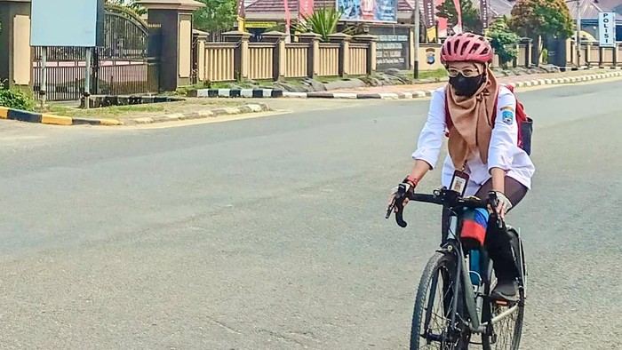 ASN di Tanjung Selor bersepeda mengenakan masker di tengah kabut asap tipis.
