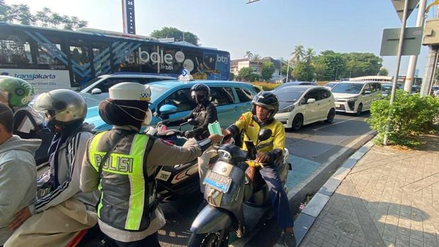 Ditlantas Polda Metro Jaya membagikan ribuan masker kepada driver ojol mencegah paparan abu vulkanik, Senin (7/9/2026).