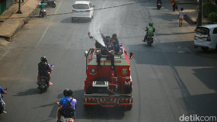 Petugas damkar melakukan pembahasan jalan imbas sebaran abu vulkanik Anak Krakatau
