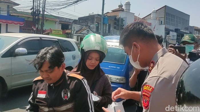 Polisi saat membagikan masker ke warga Cianjur