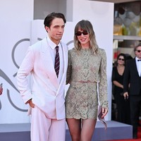 Seperti dikutip Vogue, Robert Pattinson dan Suki Waterhouse menebarkan pesona mereka di karpet merah Festival Film Venesia 2026. Pattinson mengenakan setelan jas kustom Dior Homme berwarna serba putih dengan motif pinstripe halus, yang ia padukan dengan kemeja putih, dasi garis-garis warna biru dongker dan merah, serta sepatu loafers cokelat. Foto: Dok. Getty Images, Wireimages
