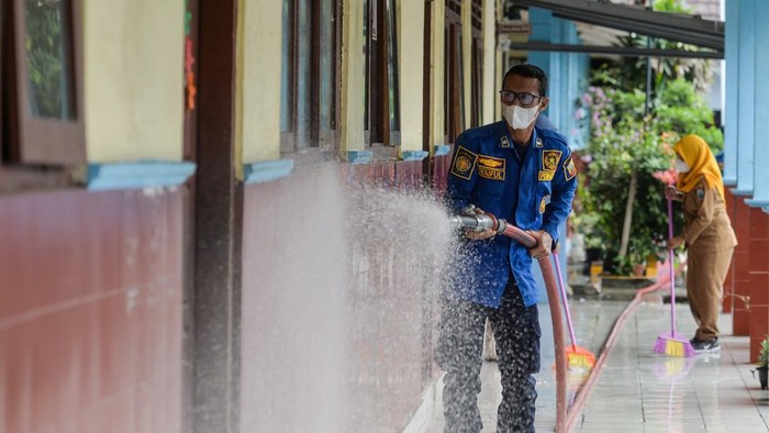 Penjaga sekolah membersihkan lantai dari abu vulkanik Gunung Anak Krakatau di SMP Negeri 1 Kalianda, Kabupaten Lampung Selatan, Lampung, Senin (7/9/2026). Pembersihan dilakukan untuk mencegah penumpukan abu vulkanik dan mempersiapkan sekolah jika pembelajaran tatap muka kembali digelar. ANTARA FOTO/Putra M. Akbar/tom.