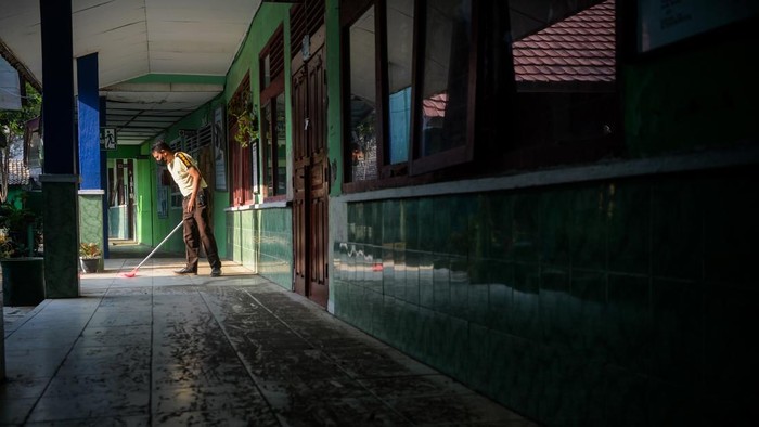Penjaga sekolah membersihkan lantai dari abu vulkanik Gunung Anak Krakatau di SMP Negeri 1 Kalianda, Kabupaten Lampung Selatan, Lampung, Senin (7/9/2026). Pembersihan dilakukan untuk mencegah penumpukan abu vulkanik dan mempersiapkan sekolah jika pembelajaran tatap muka kembali digelar. ANTARA FOTO/Putra M. Akbar/tom.