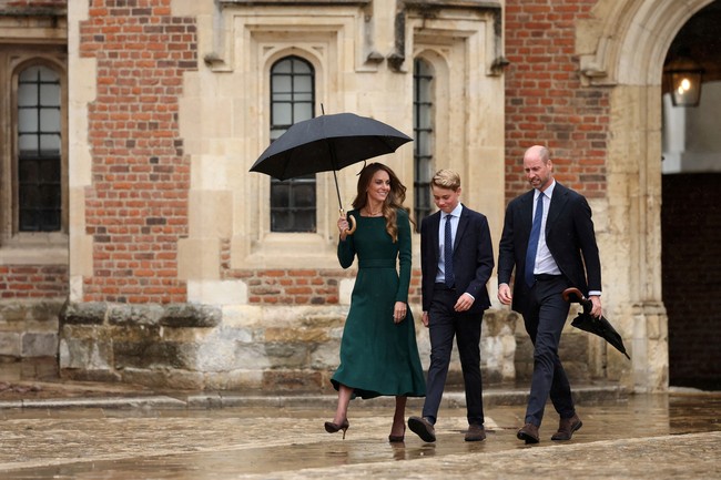 Pangeran George tampil formal dengan seragam baru berupa kemeja dan dasi bernuansa biru, dan blazer gelap sebagai luaran. Untuk bawahan celana chino, serta sepatu suede cokelat senada jadi andalan. (Foto: via REUTERS/ADRIAN DENNIS)