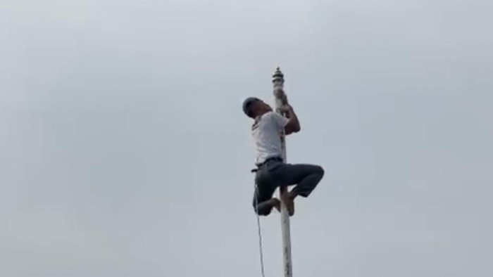 Siswa bernama Rizki Utari dengan sigap memanjat tiang bendera untuk menyambung kembali tali yang terputus.