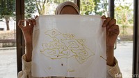   Hasil akhir proses mencanting menampilkan motif awan atau megamendung yang mulai terbentuk di atas kain. Peserta lain turut memperlihatkan hasil karya batik tulisnya yang telah selesai dicanting dengan pola serupa.Kegiatan ini memberi pengalaman langsung kepada pengunjung mengenai tahapan awal pembuatan batik tulis menggunakan canting tradisional.