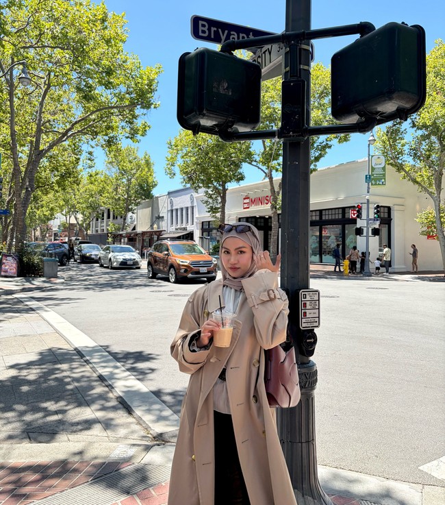 Gaya Xaviera juga bisa kamu tiru dengan mengenakan pashmina light taupe lilit yang dipadukan trench coat panjang berwarna beige. Outfit bergaya chic street style ini dipadukan dengan kemeja dalaman dan tas bahu maroon sebagai penyempurna tampilan. Foto: Dok. Instagram @xavieraaputri.