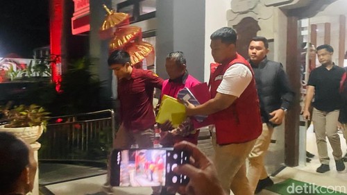 Ketua LPD Desa Adat KlungahberinisialIWD digiring menuju mobil tahanan Kejari Karangasem, Rabu (9/9/2026). (Foto: I Wayan Selamat Juniasa/detikBali)