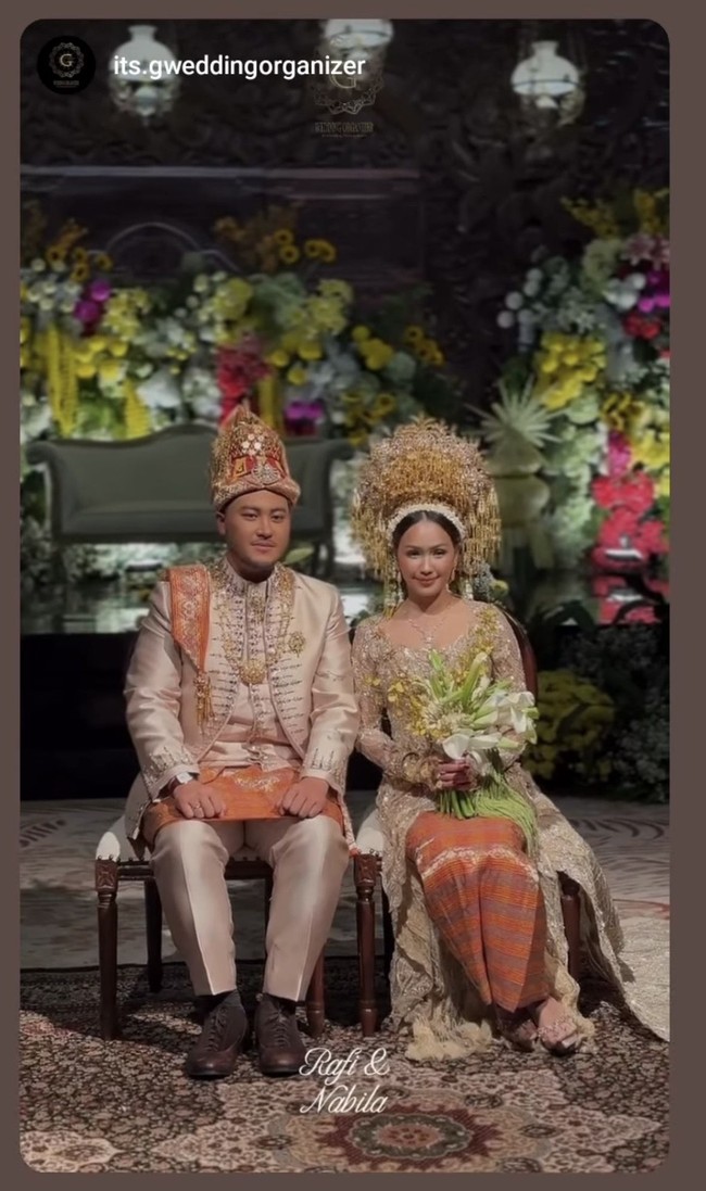 Putra sulung Annisa Trihapsari baru saja resmi meminang kekasihnya, Nabila Febrina, pada 6 September 2026. Di akad nikah kedua mempelai tampil kompak kenakan busana pengantin adat Aceh dengan nuansa coklat keemasan dan oranye. Adat Aceh sendiri dipilih karena mengikuti asal Nabila. Foto: Instagram/@adjiepangestu
