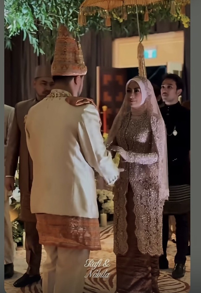 Annisa tampil anggun berbalut kebaya brokat panjang lengkap dengan hijab senada. Ia memadukannya dengan kain lilit batik berwarna coklat. Foto: Instagram/@adjiepangestu