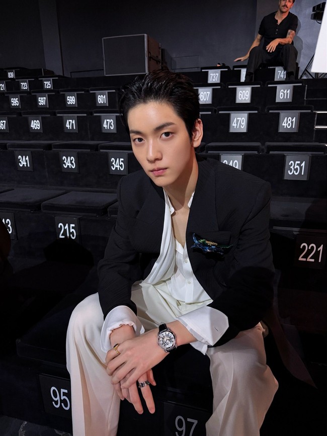 Dalam kesempatan itu, Soobin TXT memancarkan gaya maskulin sekaligus lembut. Tampil berbalut kemeja putih yang kancingnya dibiarkan terbuka, dilapisi blazer hitam, lengkap dengan syal putih yang melingkar di bahunya serta bros bunga berwarna biru sebagai statement. Foto: Instagram