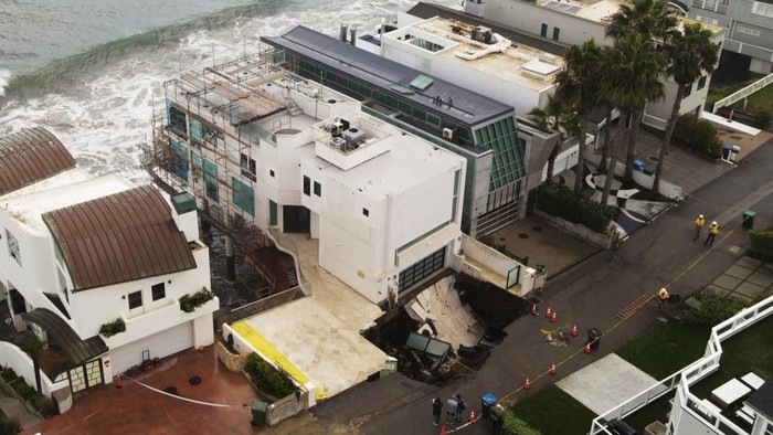 This aerial view shows a sinkhole on a street and driveway of a seaside home affected by large swells produced by Hurricane Marie in Malibu, California, on September 8, 2026. Hurricane Marie stayed well offshore of Southern California during Labor Day weekend but its large swells produced dangerous surf and rip currents, with waves reaching around 10 feet in some areas. (Photo by David Swanson / AFP)