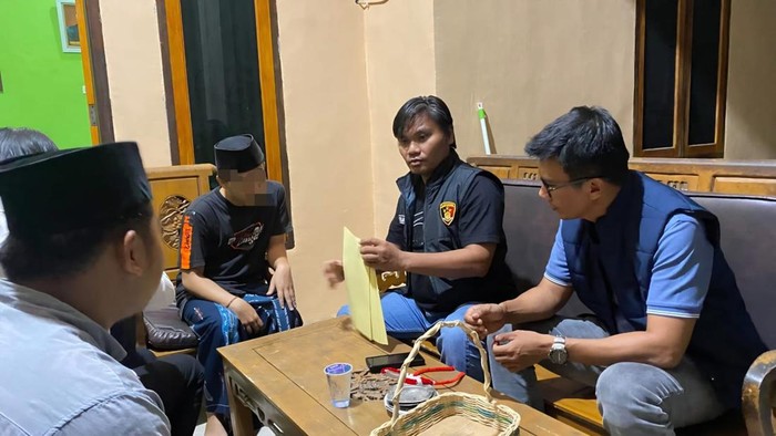 Polisi saat mengamankan pelaku.