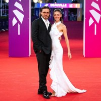 Nicola sendiri tampak memukau dalam balutan gaun sifon putih yang memiliki ekor beraksen kerut rancangan Alberta Ferretti dari koleksi 2027. Foto: AFP/GUILLAUME SALIGOT