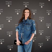 Beberapa kancing kemejanya dibiarkan terbuka hingga bagian perut sehingga baby bump terlihat jelas. Ia kemudian memadukannya dengan jeans denim model wide-leg untuk menciptakan tampilan denim dari atas sampai bawah. Foto: Getty Images/Manoli Figetakis