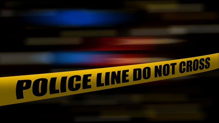 Yellow police tape at night with blurred blue and red lights from police cars and emergency vehicles. Shallow depth of field. With copy space for text.