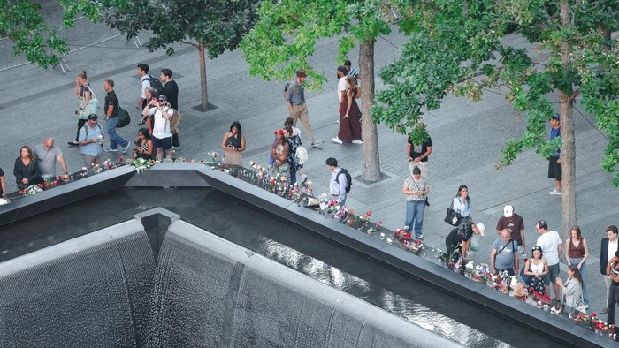 People stand by a reflecting pool during a memorial on the 25th anniversary of the September 11, 2001 attacks, in New York, U.S., September 11, 2026. Adam Gray/Pool via REUTERS