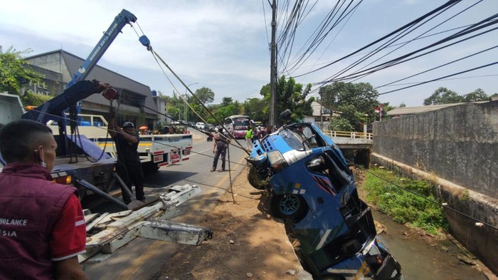 Satu unit mobil Elf yang membawa rombongan besan dari Cibitung mengalami kecelakaan hingga masuk kali di Jalan KSU, Sukmajaya, Depok, Jawa Barat (Jabar), Minggu (13/9/2026).