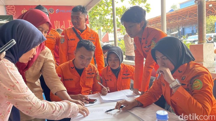 Keluarga korban yang mengecek daftar nama penumpang yang berhasil dievakuasi.