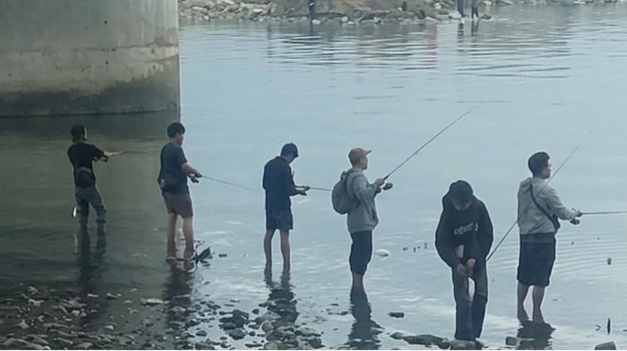 Warga ramai-ramai memancing di sungai jembatan IV Palu meski ada banyak buaya.