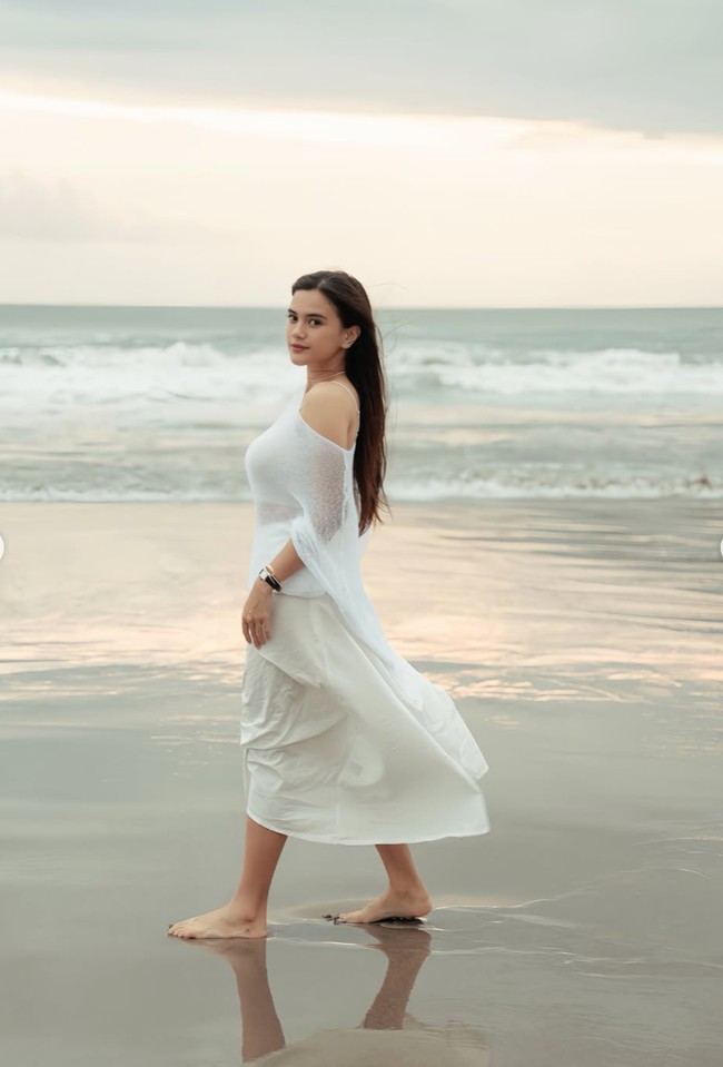 Wanita 31 tahun itu tampil mengenakan busana serba putih. Ia memadukan tanktop putih dengan rok senada dan outer menerawang. Rambut panjangnya dibiarkan terurai natural, membuat penampilannya semakin feminin. Foto: Instagram/@audimarissa