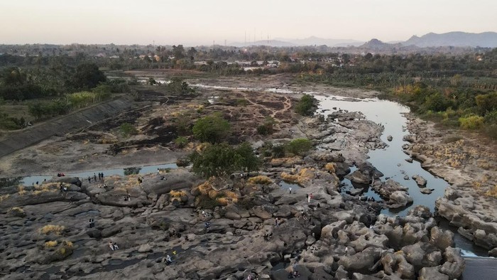 Warga berfoto di area aliran Sungai Jeneberang yang mengering di Kabupaten Gowa, Sulawesi Selatan, Minggu (13/9/2026). Area dasar sungai yang mengering akibat penurunan debit air di tengah musim kemarau dan penguatan fenomena El Nino tersebut dimanfa