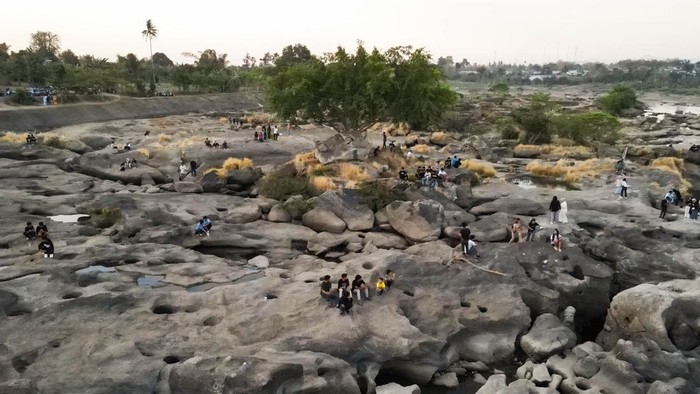 Warga berfoto di area aliran Sungai Jeneberang yang mengering di Kabupaten Gowa, Sulawesi Selatan, Minggu (13/9/2026). Area dasar sungai yang mengering akibat penurunan debit air di tengah musim kemarau dan penguatan fenomena El Nino tersebut dimanfaatkan warga sebagai destinasi wisata dadakan yang menawarkan pemandangan eksotis lekukan bebatuan tererosi. ANTARA FOTO/Arnas Padda