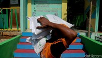 Warga membawa bantuan beras yang diterima dalam program pangan pemerintah untuk membantu memenuhi kebutuhan pokok hingga akhir 2026. 