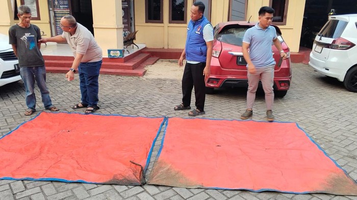 Polisi mengecek terpal yang ditemukan tim SAR. (Dok. Istimewa)