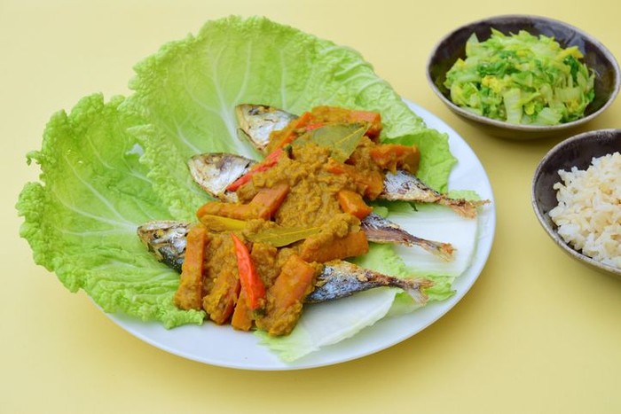 Pesmol Ikan Makarel (Indonesian food) or Mackerel fish with chili turmeric coconut milk sauce served with rice and sauteed napa cabbage