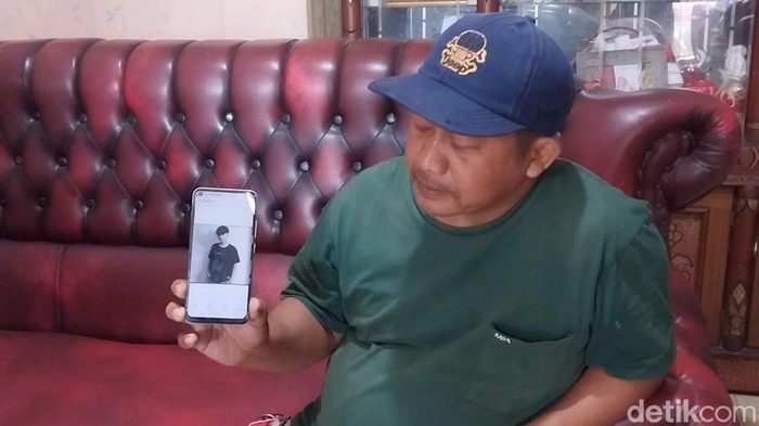 Ujang Lukman menunjukan foto anaknya, M. Fathir.