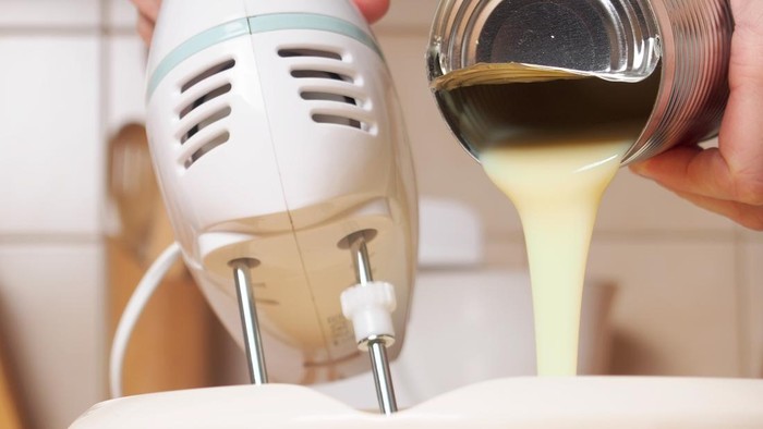 Adding sweetened condensed milk. Making butter cream filling. Making torte with buttercream filling and grated chocolate topping. Series.