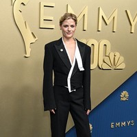Di tengah dominasi gaun, Louisa Jacobson justru bersolek dengan setelan Tom Ford yang memberi aura maskulin. Ia memakai cropped evening jacket hitam berbahan grain de poudre dengan potongan tegas, dipadukan celana evening berpotongan high-waist dan wide-leg bergaya Colbert. Penampilan putri Meryl Streep ini juga dilengkapi sepatu Selen berbahan kulit embossed dan perhiasan Tiffany & Co. (Foto: Variety via Getty Images/Gilbert Flores)
