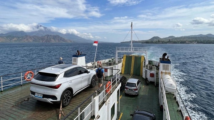 Ilustrasi mobil listrik nyebrang pulau pakai kapal.