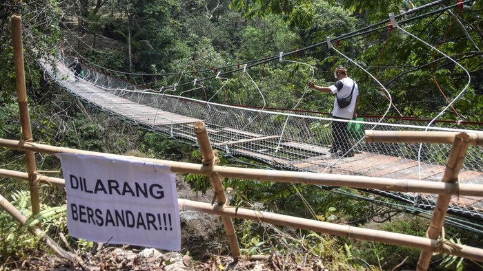 Warga menyeberangi Jembatan Pongpet yang nyaris ambruk di Desa Margacinta, Kecamatan Cijulang, Kabupaten Pangandaran, Jawa Barat, Senin (14/9/2026). Jembatan gantung sepanjang 64 meter yang menghubungkan Dusun Cidawung dan Dusun Margajaya tersebut dibangun pada 1992 dan kini dibangun kembali oleh TNI untuk mempermudah mobilitas warga, membuka akses wilayah terisolasi, serta memperlancar kegiatan ekonomi dan pendidikan. ANTARA FOTO/Adeng Bustomi/tom.