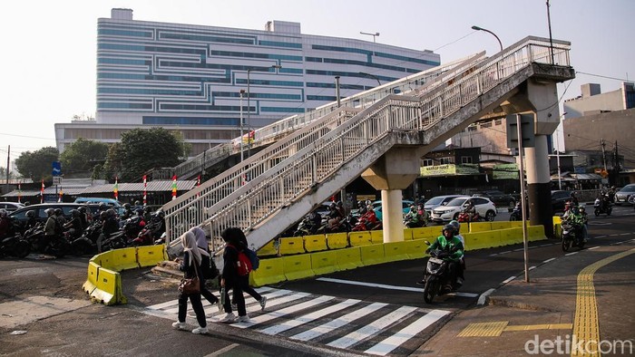 Seorang warga menyeberangi jalan menggunakan zebra cross di Jalan Dewi Sartika, Cawang, Jakarta, Selasa (15/9/2026).