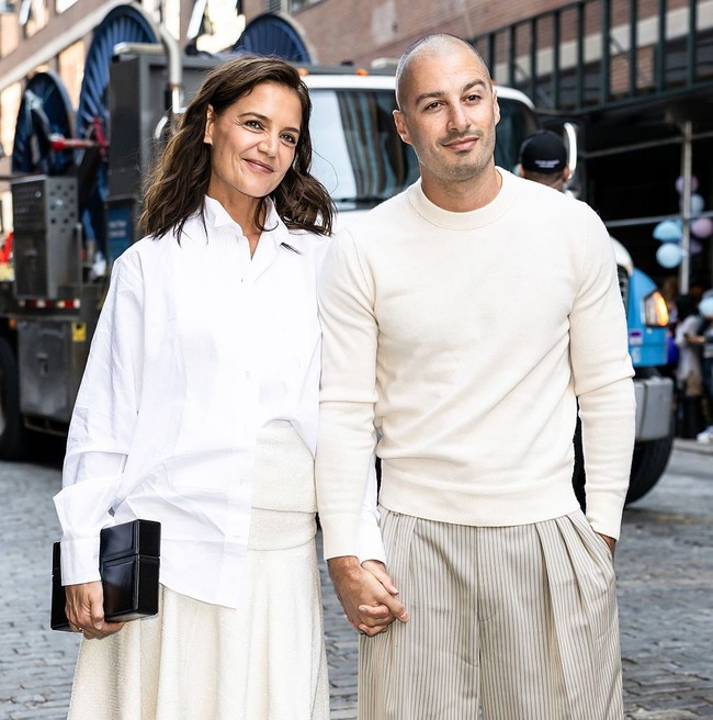 Katie Holmes dan Jason Bard Yarmosky tampil serasi dalam balutan busana serba putih. Keduanya pun bergaya mesra saat dipotret juru foto sebelum masuk ke dalam tempat fashion show Calvin Klein. Foto: Dok. Getty Images
