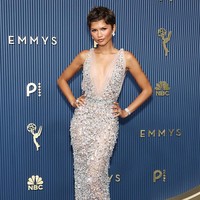 Zendaya mengenakan gaun custom Prada berbahan tulle transparan dengan potongan leher rendah berbentuk V. Detail nude illusion membuat gaun tersebut tampak seolah menyatu dengan kulit, sementara bagian belakangnya memiliki potongan rendah yang mengekspos punggung. Foto: Getty Images/Monica Schipper