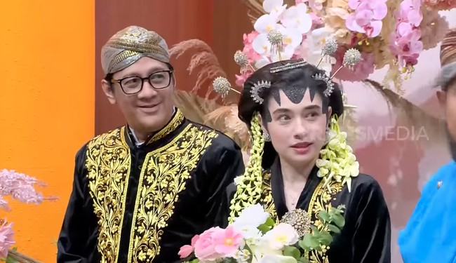 Tampil serasi, Amanda dan Andre kenakan busana pengantin adat Jawa yang didominasi warna hitam dan emas. Foto: YouTube/TransMedia