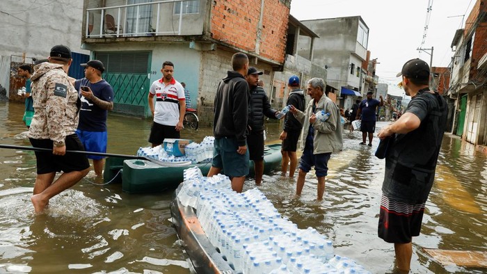 Banjir Landa Sao Paulo Brasil, 110 Keluarga Mengungsi A residents carries matresses and belongings away from the water in the flooded streets in the Jardim Pantanal neighborhood following heavy rains in Sao Paulo, Brazil, September 15, 2026. REUTERS/Tuane Fernandes