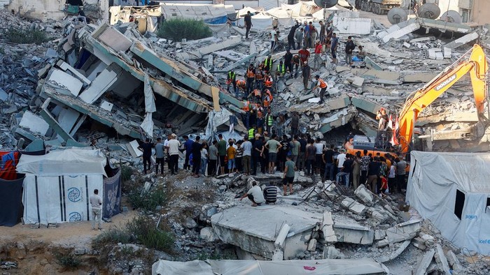 People gather as Civil Defence workers attempt to rescue those who are trapped beneath the rubble of a residential building that had been damaged in an earlier Israeli strike during the war and collapsed on Wednesday, in Gaza City, September 16, 2026