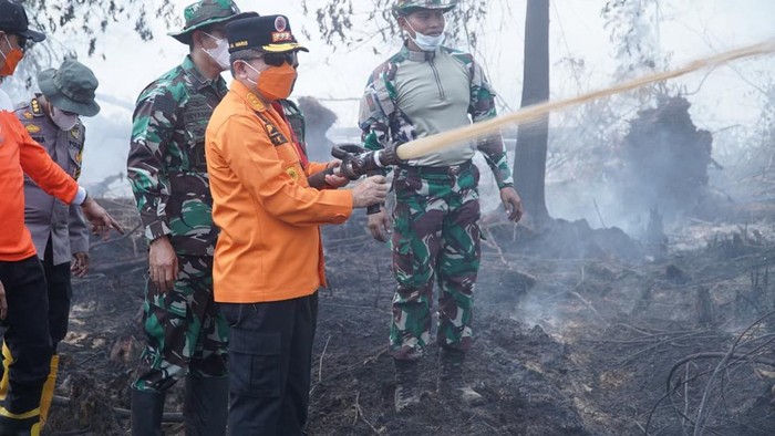Gubernur Jambi Al Haris saat ikut melakukan pendinginan lahan gambut yang terbakar