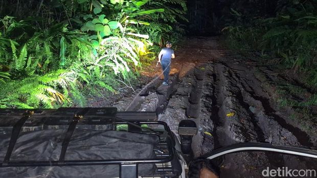 Kepala Desa Long Semamu, Malinau tengah mengevakuasi mobil pengangkut sembako yang terjebak di kubangan lumpur.