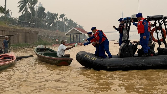 Polisi memberikan masker kepada pengemudi ketek di Sungai Batanghari, Kota Jambi, imbas kabut asap yang makin pekat