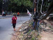 Semrawut! Kabel Fiber Optik Bergelantungan di Jalan Raya Cirendeu