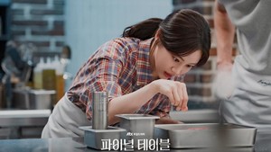 Choi Song Yi kini harus menyelamatkan Familia. Tapi karena dia gak jago masak, tugas itu jadi berat dan menantang. Apalagi sekarang dia terseret ikut kompetisi The Table: K-Chef 2026. (Foto: dok. JTBC)