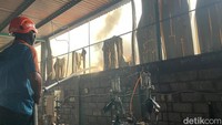  Petugas berjibaku memadamkan api yang berkobar di dalam gudang bahan baku sepatu. 