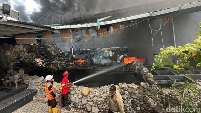 Petugas memadamkan api yang melahap pabrik sepatu PT Esa Kalen Jaya Mojokerto