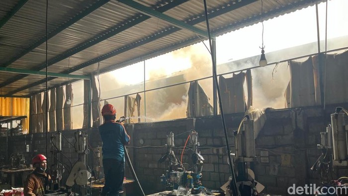 Petugas memadamkan api yang melahap pabrik sepatu PT Esa Kalen Jaya Mojokerto
